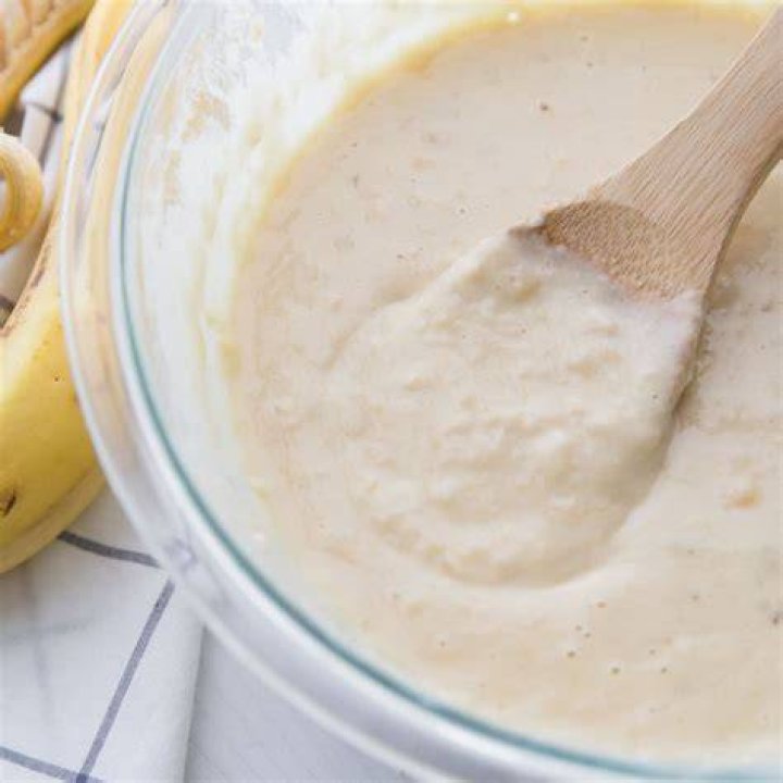 Banana pancake batter in a large white bowl.