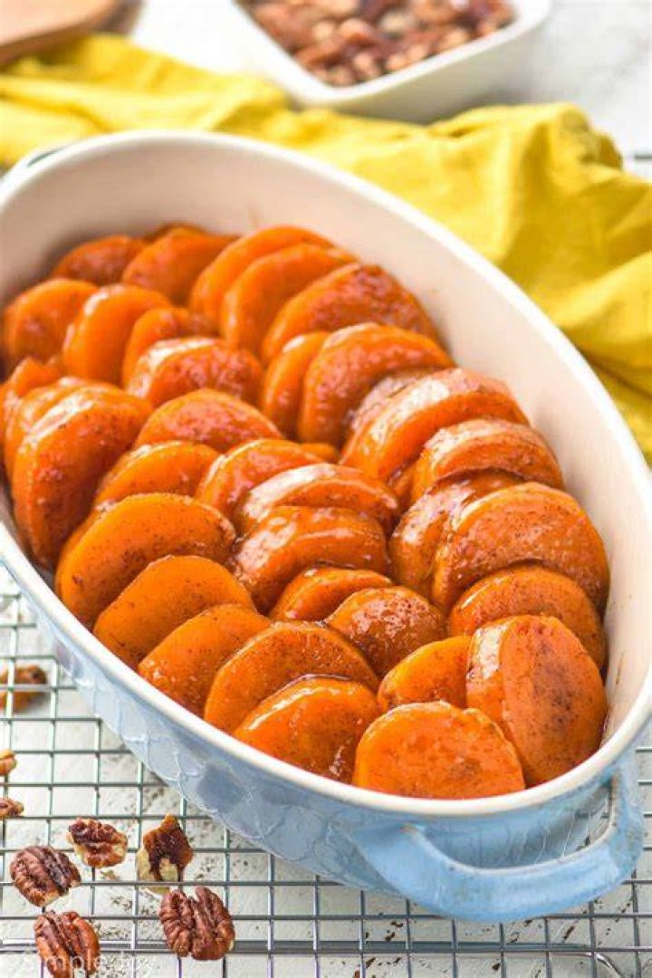 Candied sweet potatoes in a white baking dish.