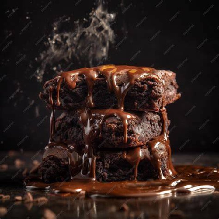 Stack of three brownies on parchment paper