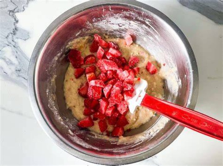 Strawberry muffin batter in a glass bowl.