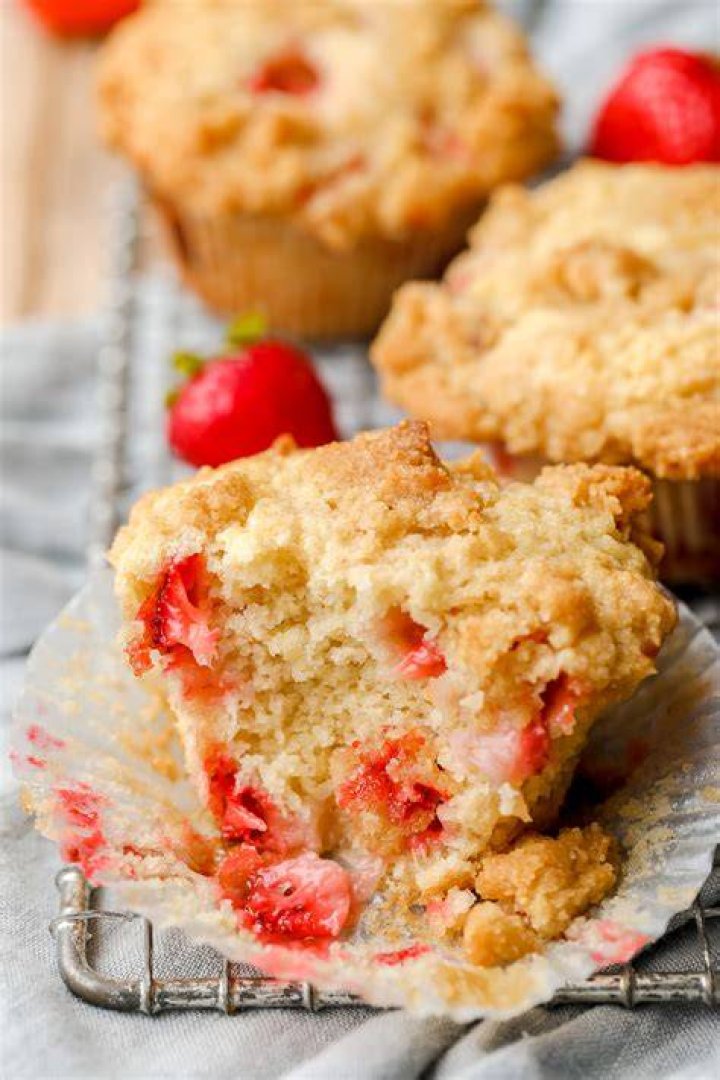 Strawberry muffin split in half and topped with butter and strawberry jam.